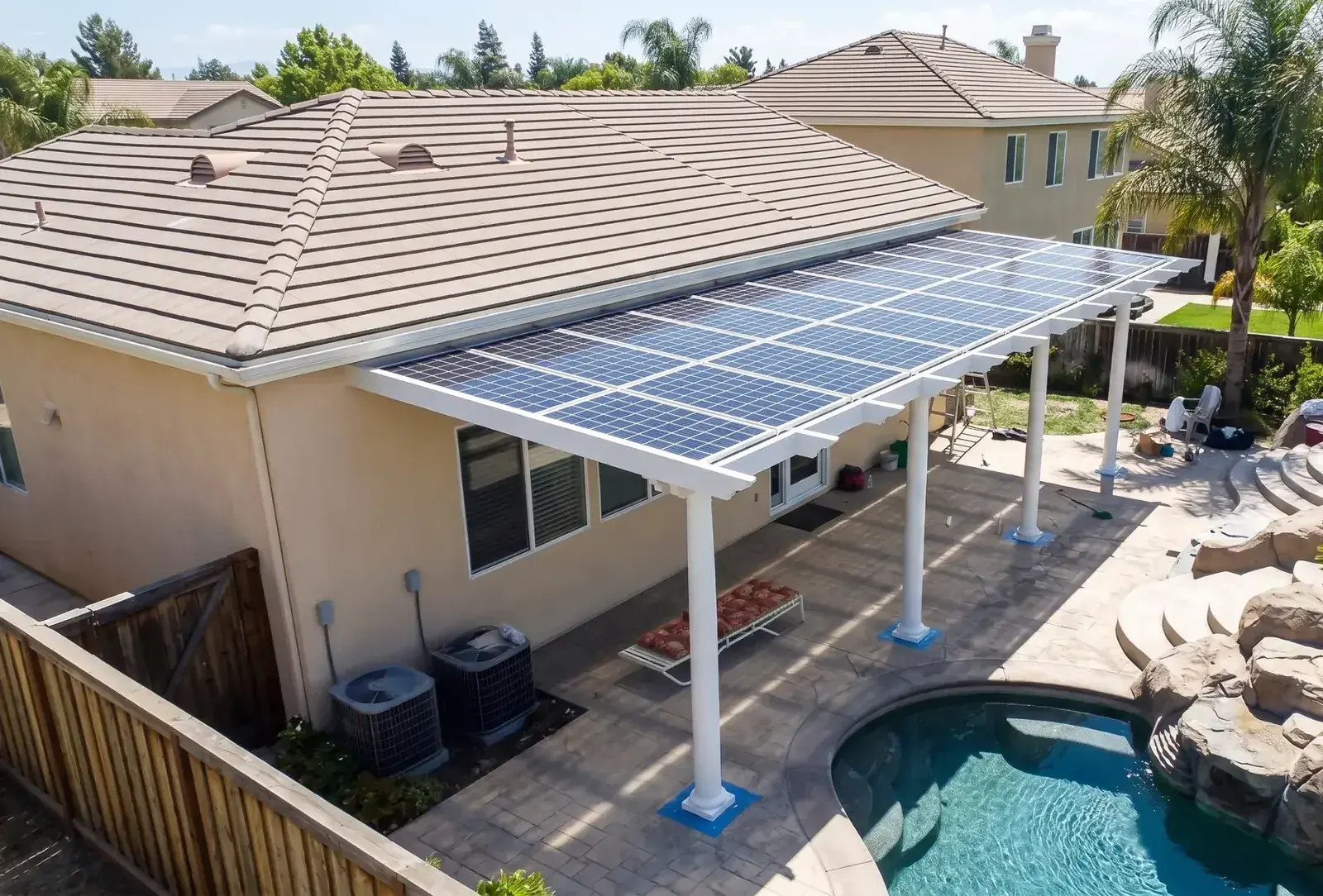 Attached solar patio cover overlooking a backyard pool